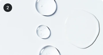 Clear liquid drops on white surface.