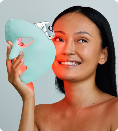 Woman using LED face mask for skincare